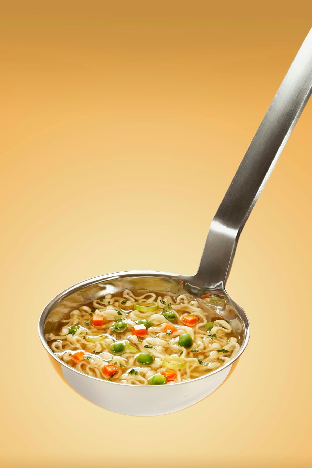 Louche versant un bouillon maison avec légumes